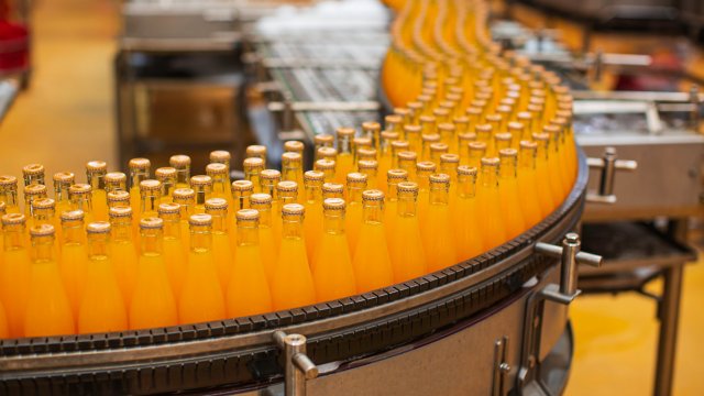 食品和饮料：果汁瓶沿传送带向下移动